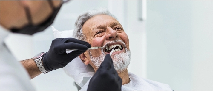 Burke Dental Center older gentleman getting his teeth examined